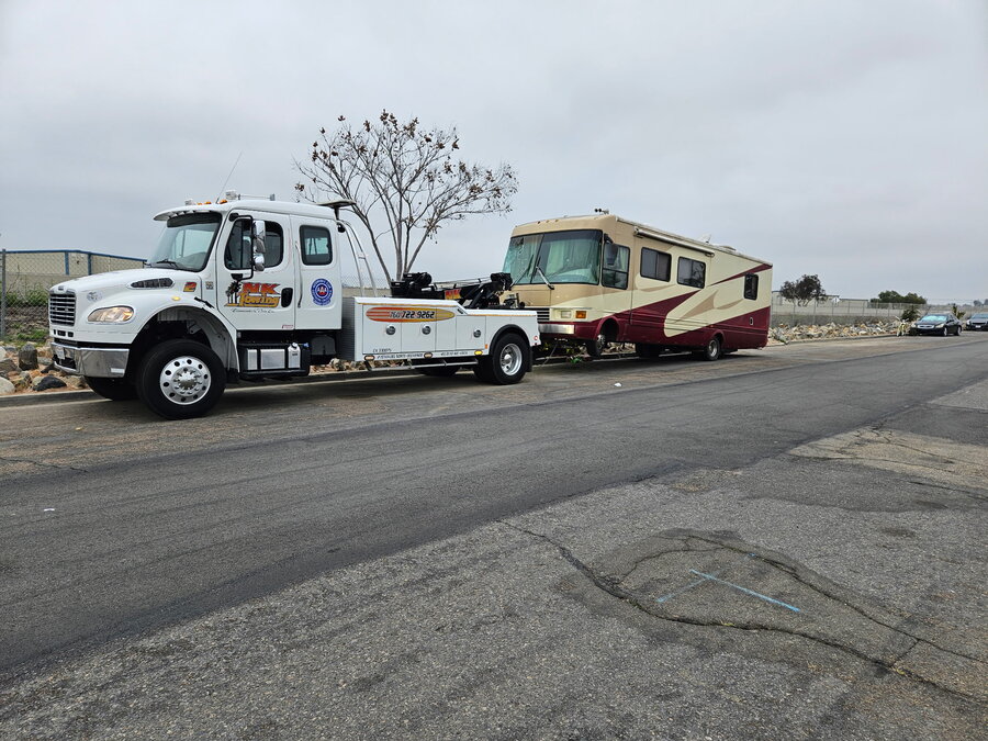 NK Towing rollback towing a motorhome in Oceanside