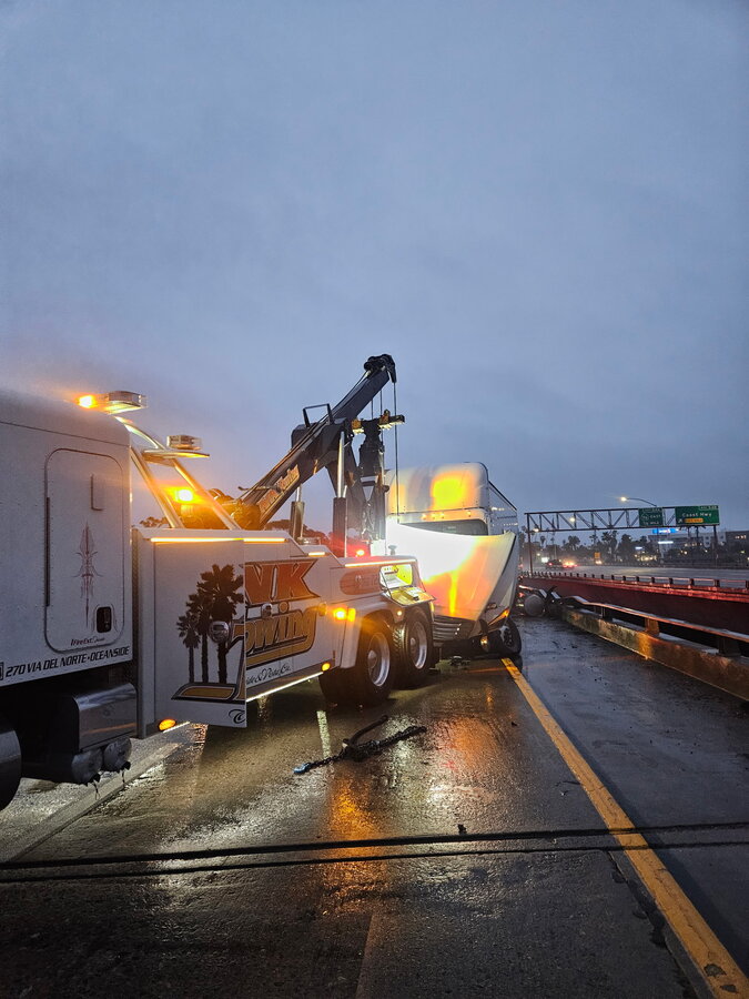 NK Towing heavy-duty wrecker recovering a semi-truck near Coast Hwy