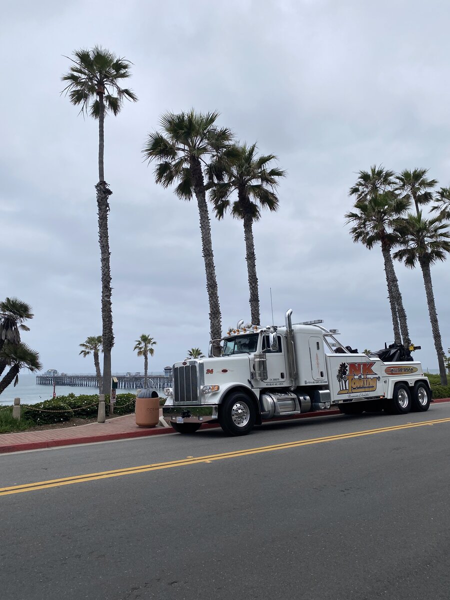 NK Towing truck parked near the Oceanside Pier